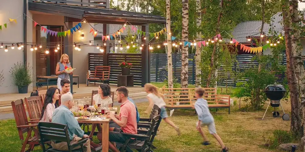 Family enjoying a mosquito free backyard dinner party with patio lighting